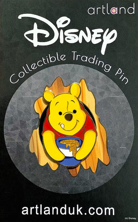 A collectible trading pin featuring the animated character Winnie the Pooh from Disney, sticking out of a tree hole with a jar of honey.